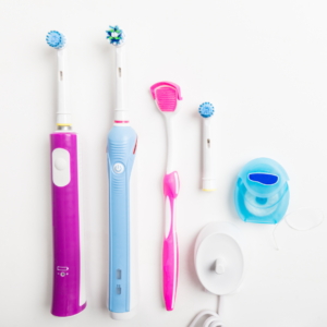 Various oral hygiene tools, including toothbrushes and floss, displayed alongside a tongue scraper for a comprehensive dental care routine.