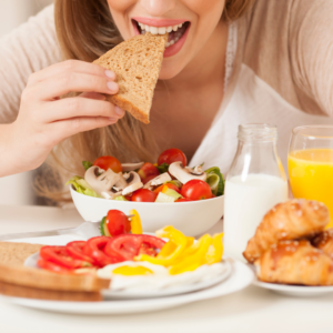 Woman enjoying a healthy breakfast with fruit and toast.