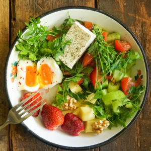 Salad with poached eggs and vegetables for a balanced breakfast.