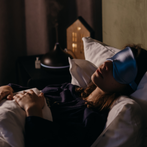 A woman sleeping peacefully with an eye mask, highlighting quality sleep practices to restore balance for Pitta energy