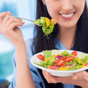 Woman enjoying a nutritious salad as part of an Ayurvedic anti-inflammatory diet.