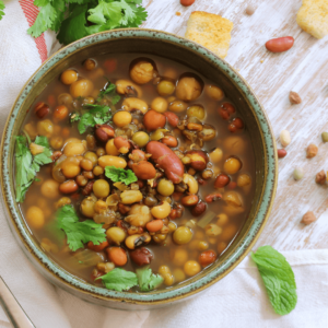 A bowl of warm mixed lentil soup with fresh herbs, supporting digestion in Ayurveda
