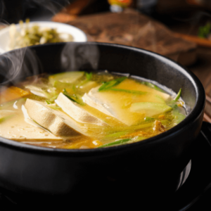 A bowl of warm miso soup with tofu and greens, a digestive-friendly meal in Ayurveda