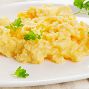 A plate of warm scrambled eggs garnished with fresh herbs, a gentle and nourishing breakfast for digestion