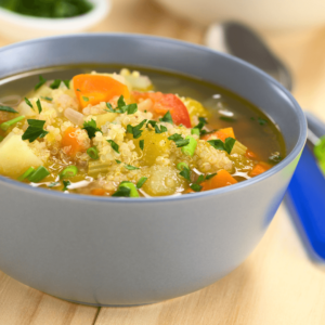 A bowl of homemade vegetable soup with fresh herbs, supporting gut health and digestion in Ayurveda