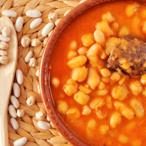 A bowl of white bean stew in a rich tomato sauce, a comforting Ayurvedic dish for digestion