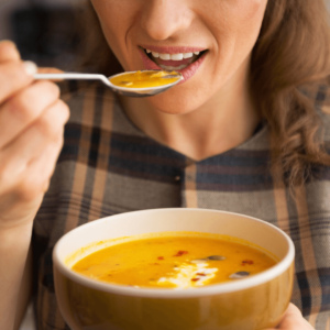 person sipping a bowl of warm soup for good digestion.