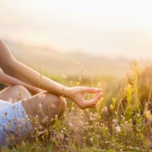 Person meditating in a natural setting, representing harmony with nature through Ayurvedic practices.