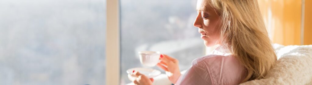 women taking her tea and enjoying the morning sun