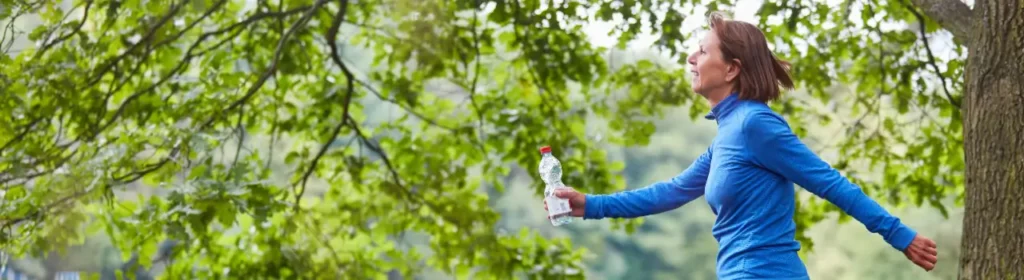 Midlife woman walking outdoors to reduce stress and mental inflammation.
